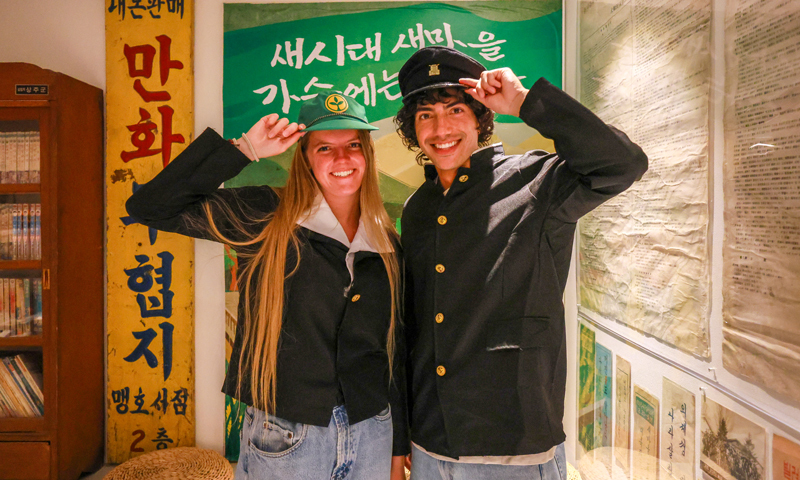 A group of foreign tourists participating in a 'K-Quest Tour' escape room game in Korea.