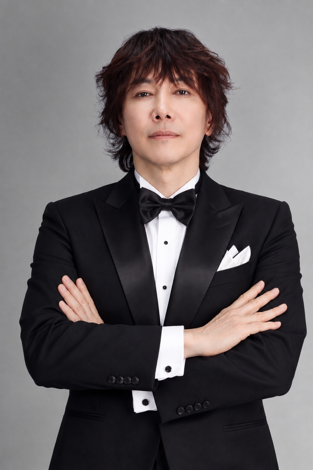 黒いタキシード姿で腕を組む歌手キム・ジャンフン