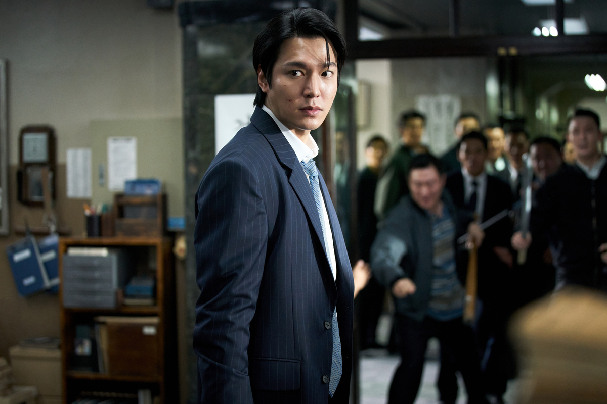 映画『暗殺者たち』でスーツ姿の人物が振り返る場面