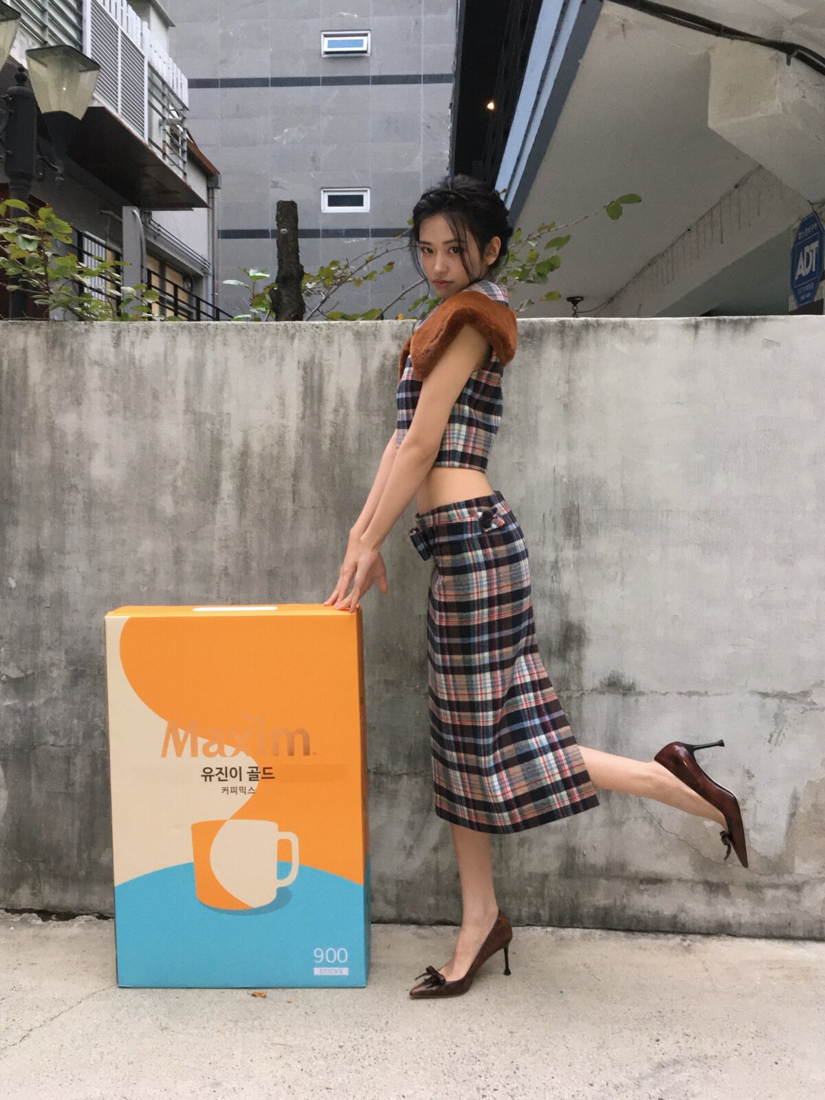 茶系のチェック柄トップスとスカートを着たIVEアン・ユジン