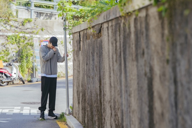 Seo In-guk in casual sportswear and black ball cap in See You At Work Tomorrow drama still
