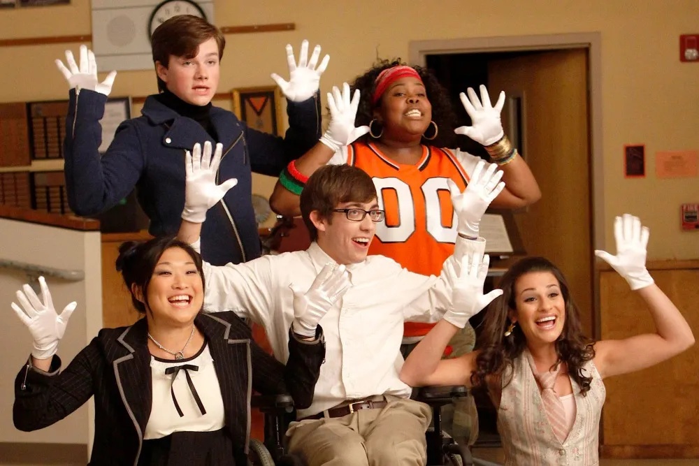 白い手袋を着け、グリークラブの仲間たちとポーズを取る『Glee』出演者