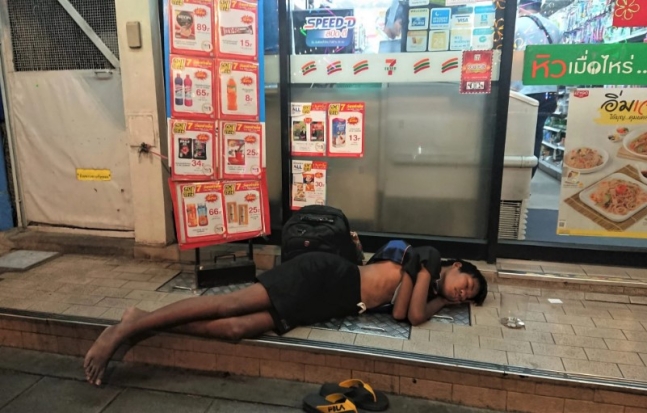 태국 유명 관광지에서 구걸하는 사람들이 늘어나자 정부가 단속에 나섰다. 사진은 한 소년이 세븐일레븐 편의점 앞에서 구걸하다가 잠든 모습. /사진 =SCMP 엑스(X·옛 트위터) 화면 캡처