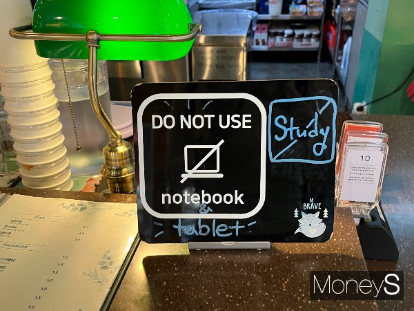 카페에서 공부를 하는 '카공족'이 많아지면서 일부 카페 사장들이 콘센트 이용료를 부과하거나 카페 내 노트북 사용을 금지하는 방안을 강구하고 있다. 지난 24일 서울 종로구 한 카페에 노트북과 태블릿 사용을 금지하는