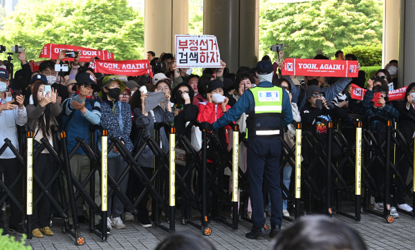 윤석열 전 대통령 지지자들이 윤 전 대통령을 보기 위해 서울중앙지방법원에 모여들었다.사진은 윤석열 전 대통령이 12일 오전 서울 서초구 중앙지방법원에서 열린 내란 우두머리 혐의,직권남용 권리행사방해 혐의 사건 3