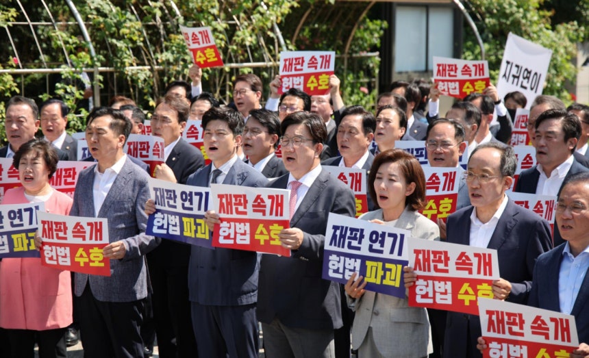김용태 국민의힘 비상대책위원장과 권성동 원내대표 등 참석 의원들이 11일 오전 서울 서초구 서울고등법원에서 법원의 이재명 대통령 공직선거법 위반 파기환송심 기일 추후 지정 결정을 비판하는 현장의원총회를 열고 구호를