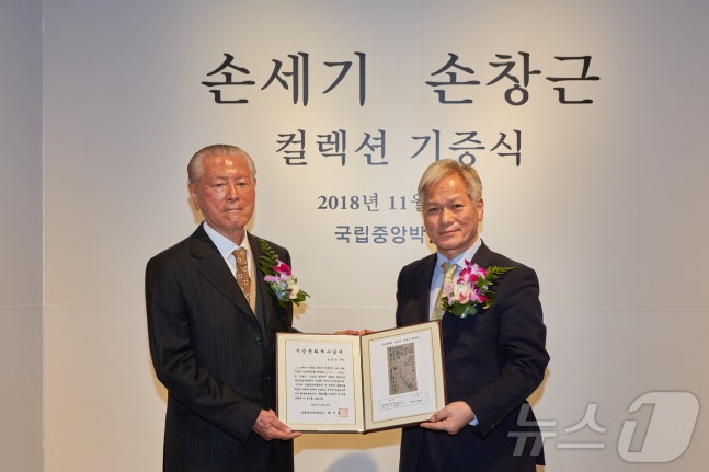 Late Son Chang-geun (left) pictured at a donation ceremony held at the National Museum of Korea in November 2018 with the museum director at the time. ⓒ News1