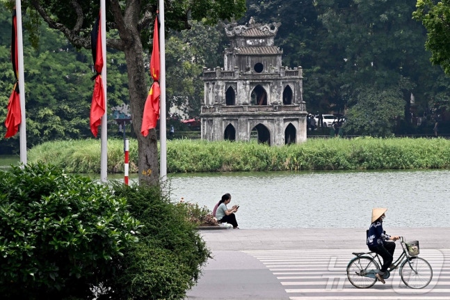 Flags at half-mast with black ribbons draped around them to mourn the passing of Truong Tan Sang, the Communist Party Secretary General of Vietnam, at a flag-raising ceremony in Hanoi, Vietnam on the 22nd. Truong Tan Sang, the top-ranking official in Vietnam, passed away on the 19th at the age of 80.