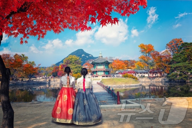 A scene of hotel guests at The Plaza wearing hanbok and touring a palace (provided by Hanwha Hotels & Resorts)