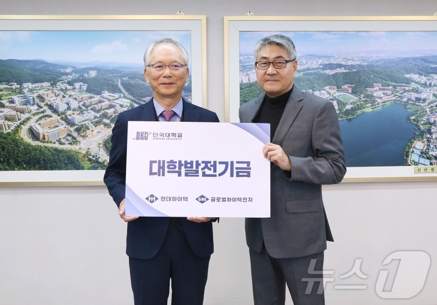 오정기 대표(왼쪽)가 안순철 총장(오른쪽)에게 발전 기금을 기탁하고 기념촬영을 하고 있는 모습.(단국대 제공)