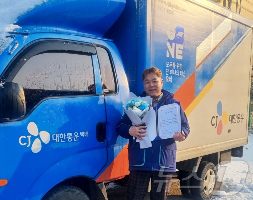 CJ대한통운 택배기사 배철 씨가 남양주에서 화재를 막은 공로로 수령한 표창장을 들고 기념 촬영을 하고 있다.(CJ대한통운 제공)