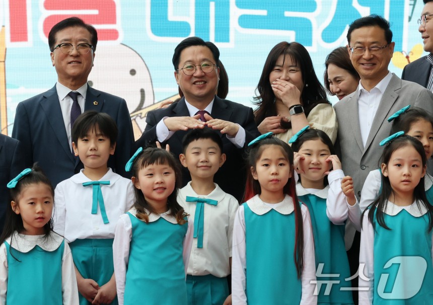 이장우 대전시장이 5일 대전 유성구 어린이회관에서 열린 제103주년 어린이날 기념행사에서 기념촬영에 앞서 비가 내리자 손으로 어린이 비를 막아주고 있다.2025.5.5/뉴스1 ⓒ News1 김기태 기자