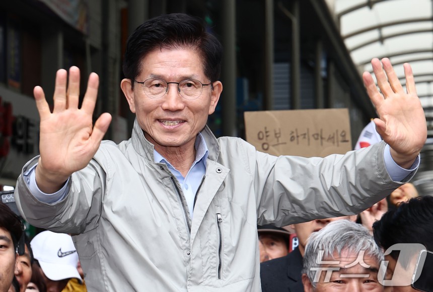 김문수 국민의힘 대통령 후보가 6일 경북 포항시 죽도시장에서 시민들을 향해 인사하고 있다.뒷편에는 한 지지자가 '양보 하지 마세요'라고 적힌 종이를 들어보이고 있다.2025.5.6/뉴스1 ⓒ News1 김민지 기