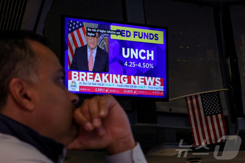 뉴욕증권거래소(NYSE)에서 TV 스크린을 통해 금리동결 결정뉴스가 나오는 가운데 트레이더들이 일하고 있다.2025.5.7 ⓒ 로이터=뉴스1