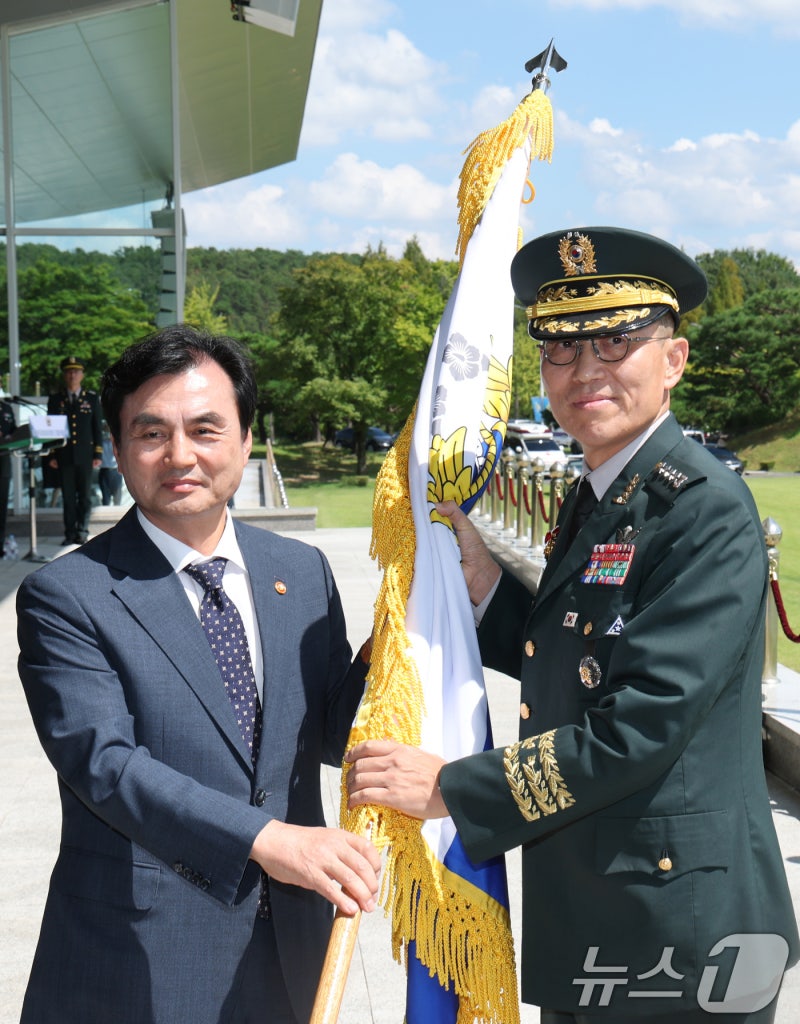 신임 <b>참모총장</b>에게 <b>육군</b>기 이양하는 안규백 국방장관