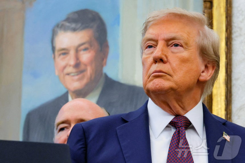 백악관 오벌오피스(미 대통령 집무실)에 걸려 있는 로널드 레이건 전 대통령 앞에 서 있는 도널드 트럼프 미국 대통령. ⓒ 로이터=뉴스1 ⓒ News1 류정민 특파원