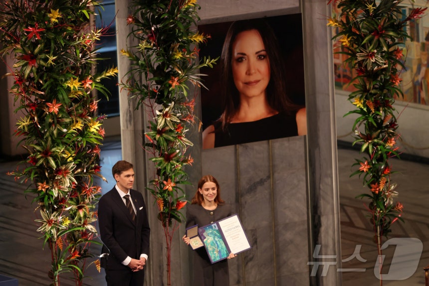 2025년 노벨평화상 수상자인 마리아 코리나 마차도의 딸 아나 코리나 소사가 10일(현지시간) 노르웨이 오슬로에서 열린 노벨평화상 시상식에서 마리아를 대신해 노벨평화상을 수상하고 있다.2025.12.10 ⓒ 로이터