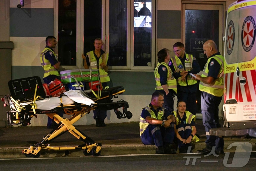 14일(현지시간) 호주 시드니 본다이 비치에서 총격 사건이 발생한 가운데,의료진들이 휴식을 취하고 있다.ⓒ AFP=뉴스1 ⓒ News1 김성진 기자