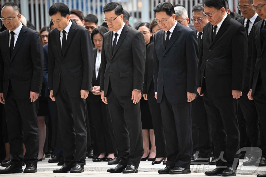 29일 존 리 행정장관 등 홍콩 정청의 간부들이 센트럴에 위치한 정부청사 앞에서 아파트 화재 참사에 희생된 이들을 위해 묵념하고 있다.ⓒ AFP=뉴스1 ⓒ News1 박형기 기자