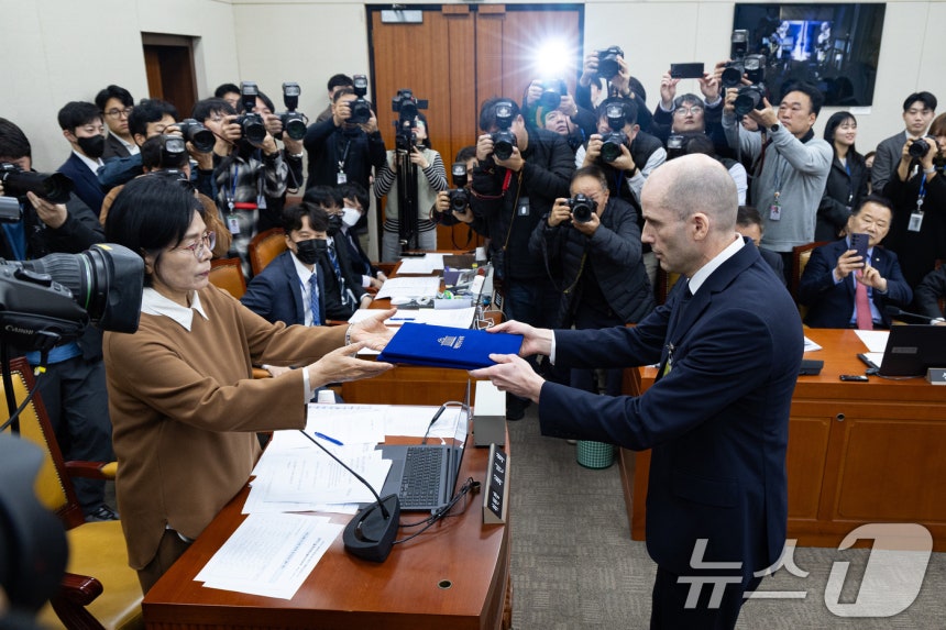 해롤드 로저스 쿠팡 임시 대표가 17일 서울 여의도 국회 과학기술정보방송통신위원회에서 열린 쿠팡 개인정보 유출 사고 관련 청문회에서 증인 선서를 마친 후 최민희 과방위원장에게 선서문을 전달하고 있다.2025.12.