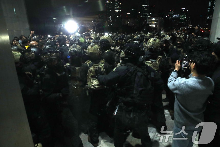 지난해 12월 4일 새벽 서울 여의도 국회 본청 앞에서 경내로 진입하려는 계엄군과 국회 관계자들이 몸싸음을 벌이고 있다.2024.12.4/뉴스1 ⓒ News1 이광호 기자