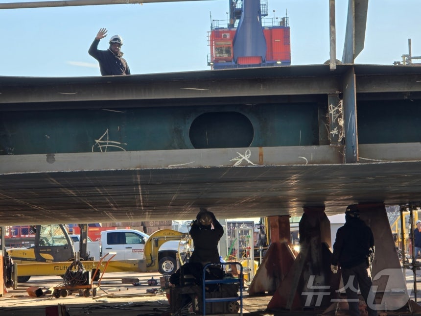지난 22일(현지시간) 미국 펜실베이니아주 필라델피아에 위치한 한화필리조선소에서 작업 중이던 근로자가 취재진을 향해 손을 들어 인사하고 있다.2025.12.25.ⓒ News1 류정민 특파원