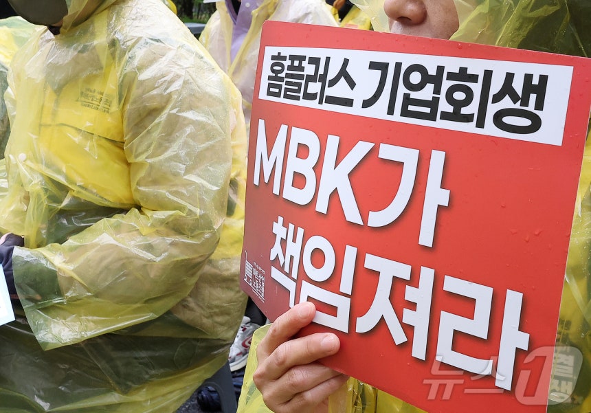 민주노총 서비스연맹 마트산업노조 지부 회원들이 서울 종로구 MBK파트너스 앞에서 열린 'MBK가 책임져라 확대간부 결의대회'에서 피켓을 들고 있다.2025.4.14/뉴스1 ⓒ News1 김진환 기자