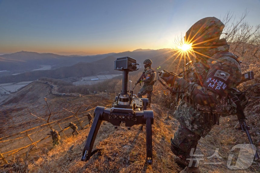 육군 5사단 열쇠부대 장병들이 2026년 병오년(丙午年)을 앞두고 경기 연천군 접경지역에서 다족 보행 로봇과 함께 일출시간대 철책 경계 근무를 하고 있다.육군은 지상로봇운용팀을 통해 장병이 접근하기 어려운 지역에서