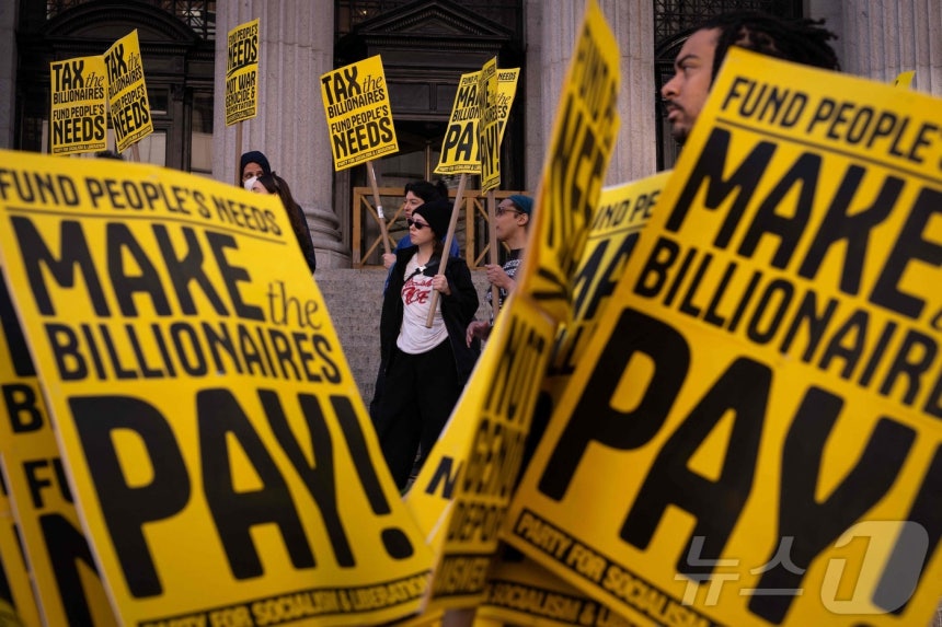 2025년 4월 15일‘세금의 날’을 맞아 뉴욕시에서 시위대가 억만장자들에게 더 많은 세금을 부과하라고 요구하며 집회를 열었다.활동가들은 보편적 의료,<a href=