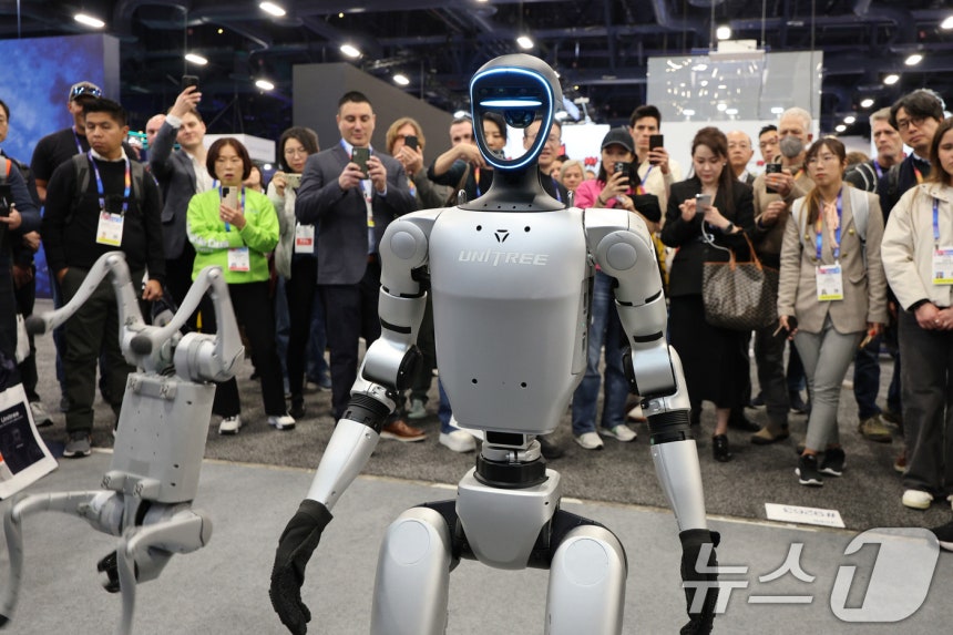 세계 최대 정보기술(IT)·가전 전시회 'CES 2025' 개막일인 7일(현지시간) 미국 네바다주 라스베이거스 컨벤션센터(LVCC)에 마련된 중국 유니트리 부스에서 관람객들이 로봇을 살펴보고 있다.2025.1.8/