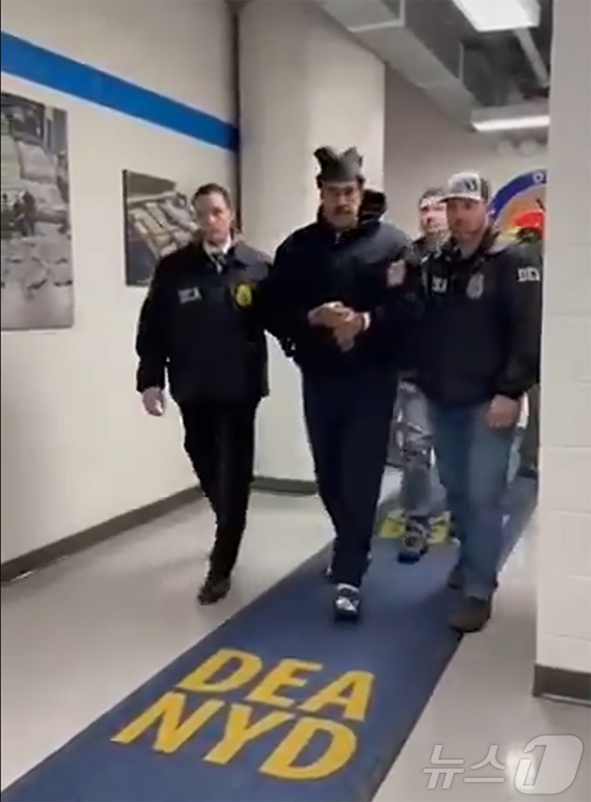 니콜라스 마두로 베네수엘라 대통령이 3일(현지시간) 미국 마약단속국(DEA) 요원에게 이끌려 '퍼프 워크'(perp walk·수사기관이 피의자를 언론 카메라에 의도적으로 노출시키는 행위)를 하는 모습이 공개됐다.(