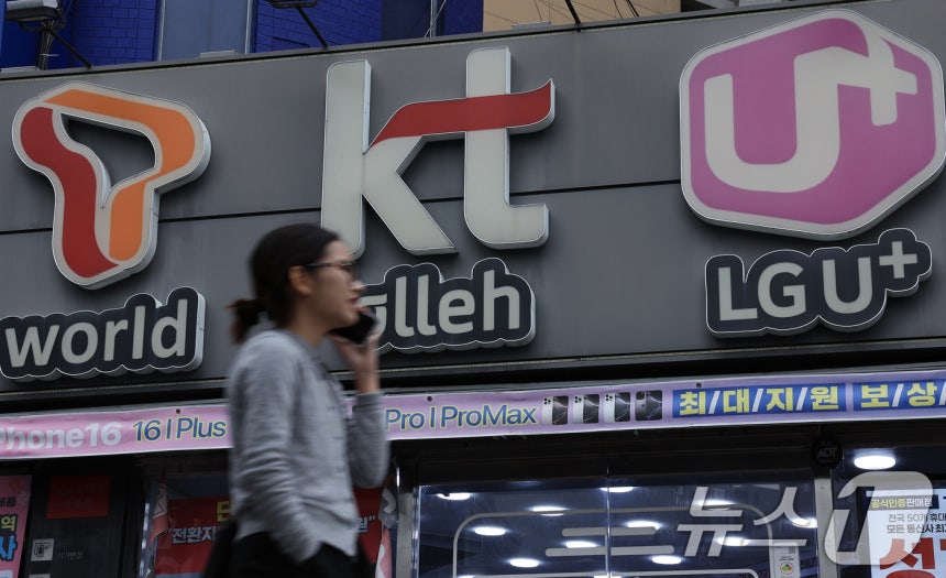 지난해 3월 12일 서울의 한 휴대폰 매장 앞으로 시민이 지나가고 있다.2025.3.12/뉴스1 ⓒ News1 박정호 기자