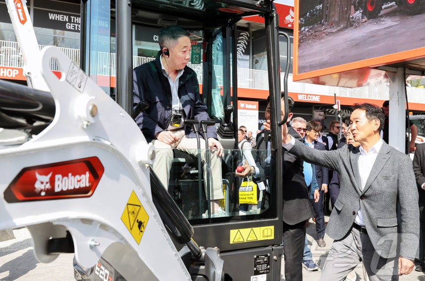 박정원 두산그룹 회장이 독일 건설기계 전시회 '바우마 2025'에서 두산밥캣의 미니굴착기 신제품에 탑승해 스캇 박 두산밥캣 부회장의 설명을 듣고 있는 모습.(두산그룹 제공.재판매 및 DB 금지) 2025.4.13/