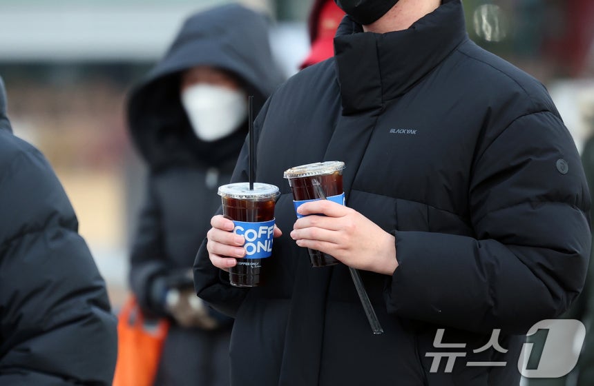 서울 종로구 광화문네거리에서 두터운 옷차림을 한 시민이 차가운 음료를 들고 발걸음을 옮기고 있다.2025.12.3/뉴스1 ⓒ News1 이호윤 기자