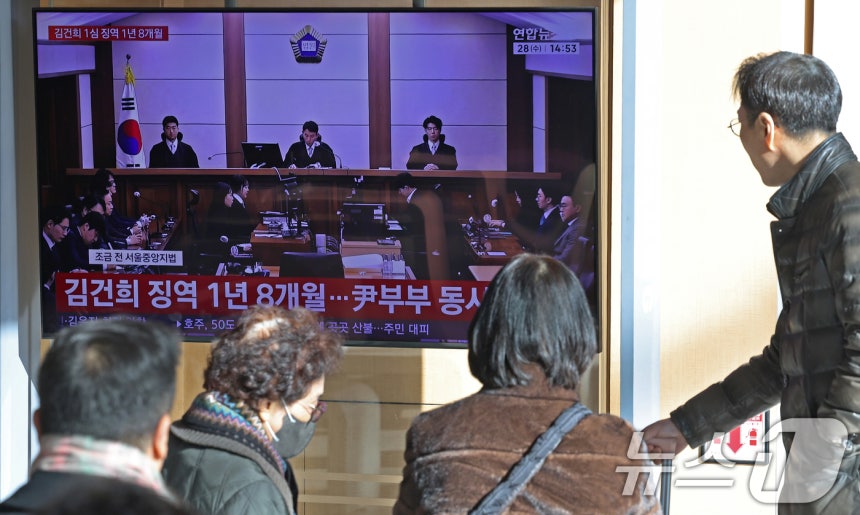 28일 오후 서울역 대합실에서 시민들이 김건희 여사의 자본시장법·정치자금법 위반, 특정범죄 가중처벌법상 알선수재 혐의 1심 선고 공판 생중계를 지켜보고 있다. 서울중앙지법 형사합의