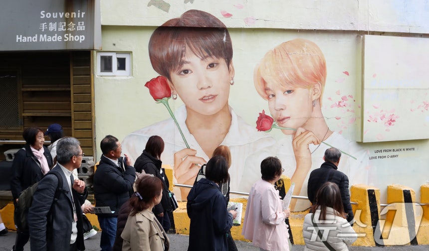 방탄소년단(BTS) 컴백 공연을 이틀 앞둔 19일 부산 서구 감천문화마을에서 외국인 관광객들이 부산이 고향인 BTS 멤버 정국·지민이 그려진 대형 벽화를 배경으로 기념촬영을 하고 있다.2026.3.19 ⓒ 뉴스1 