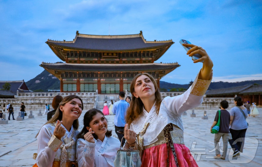 경복궁 야간 관람이 시작된 3일 오후 서울 종로구 경복궁을 찾은 외국인 관광객들이 근정전을 배경으로 셀카를 찍고 있다.2025.9.3 ⓒ 뉴스1 김진환 기자