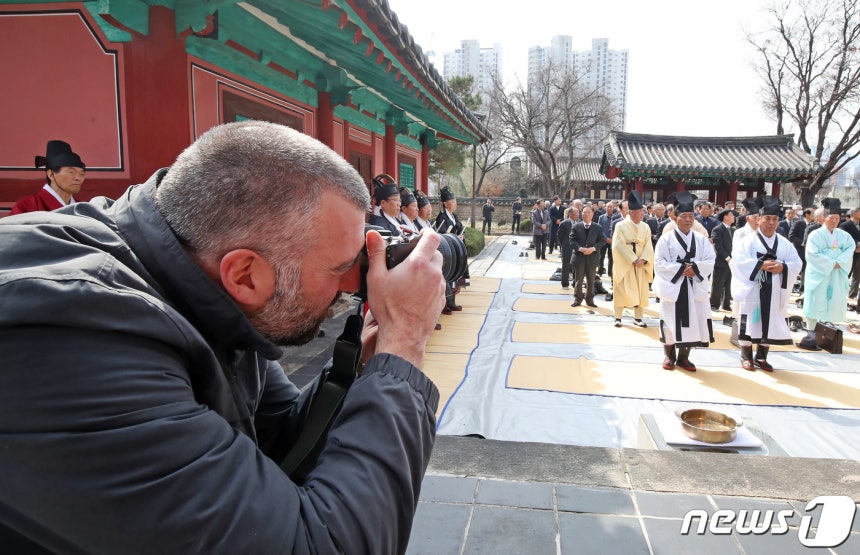 대구 중구 대구향교를 찾은 스페인 관광객이 공기(孔紀) 2575년 춘계 석전대제를 촬영하고 있다.2024.3.14 ⓒ 뉴스1