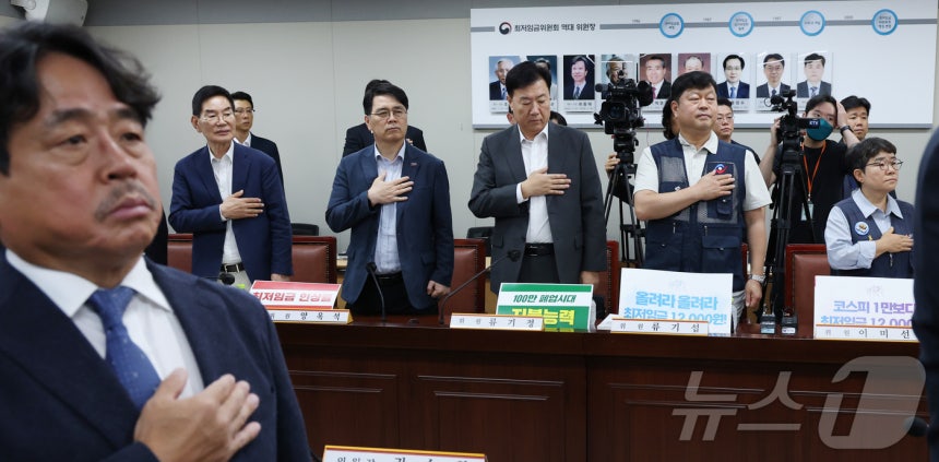 권순원 최저임금위원회 위원장을 비롯한 노사 위원들이 지난 2일 세종시 정부세종청사 최저임금위원회에서 열린 2027년도 최저임금위원회 11차 전원회의에 앞서 국민의례를 하고 있다.2026.7.2 ⓒ 뉴스1 김기남 기