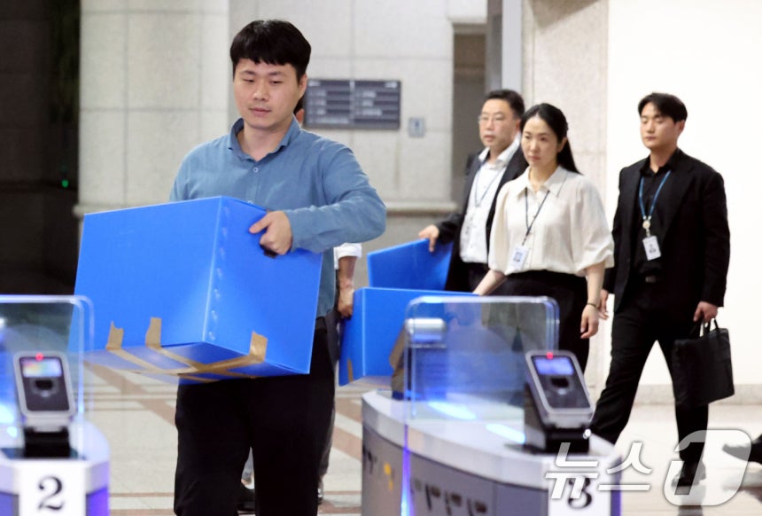6·3 지방선거 투표용지 부족 사태를 수사 중인 검·경 합동수사본부 관계자들이 23일 오후 경기 과천시 중앙선거관리위원회에 대한 압수수색을 마친뒤 압수상자를 들고 나서고 있다.이날 검·경 합동수사본부는 선거관리위원