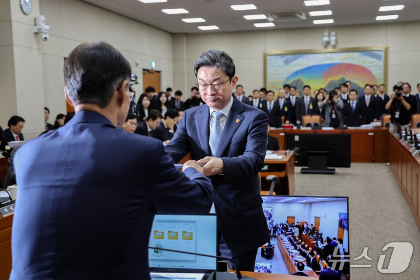 이억원 금융위원장이 8일 서울 여의도 국회에서 열린 정무위원회 국정감사에 출석해 증인선서 후 유동수 정무위원장에게 선서문을 제출하고 있다. 2026.10.8 ⓒ 뉴스1 김도우 기자