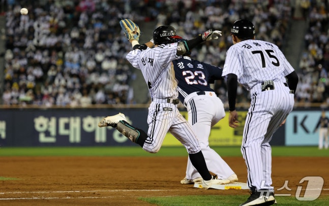 14일 오후 서울 송파구 잠실야구장에서 열린 프로야구 '2026 신한 SOL KBO 와일드카드 결정전 1차전' 두산 베어스와 LG 트윈스의 경기, LG 신민재가 8회말 1사 1,3루 상황에서 타점을 올리는 스퀴즈 번트를 성공하고 있다. 2026.10.14 ⓒ 뉴스1 김진환 기자