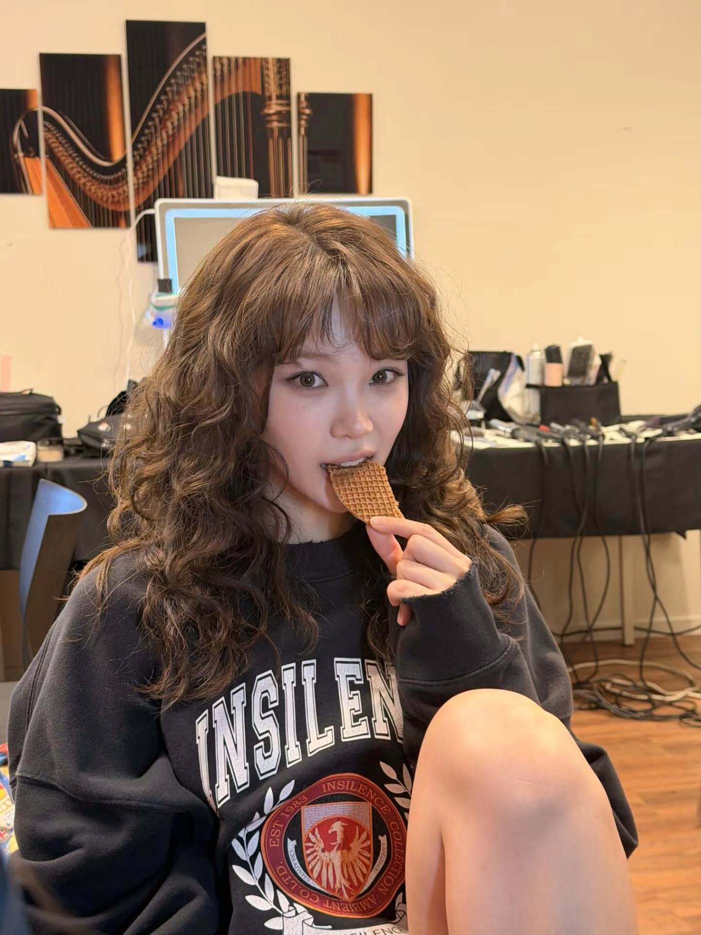 くるくるとした茶色のパーマヘアで、ワッフル菓子を手にするキム・チェウォン