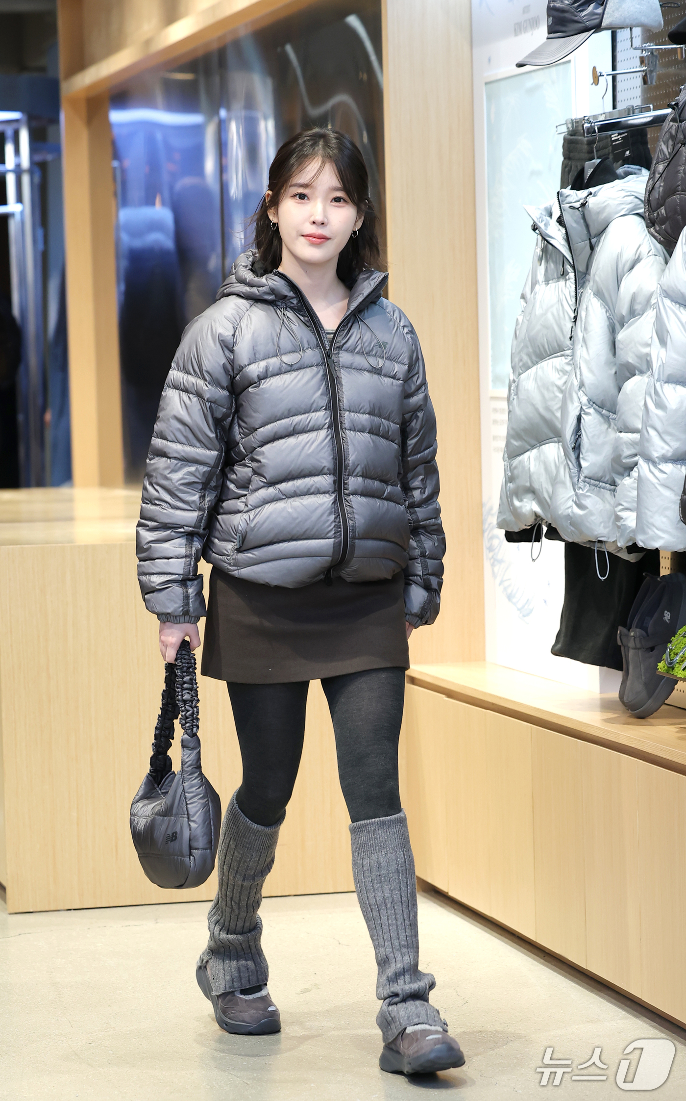 グレーのダウンジャケットと黒いミニスカート姿でポーズを取るIU