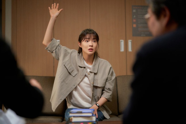 映画『修能、出題の秘密』で、教師メン・ボラム役のイ・ソンビンが会議室で手を挙げる場面