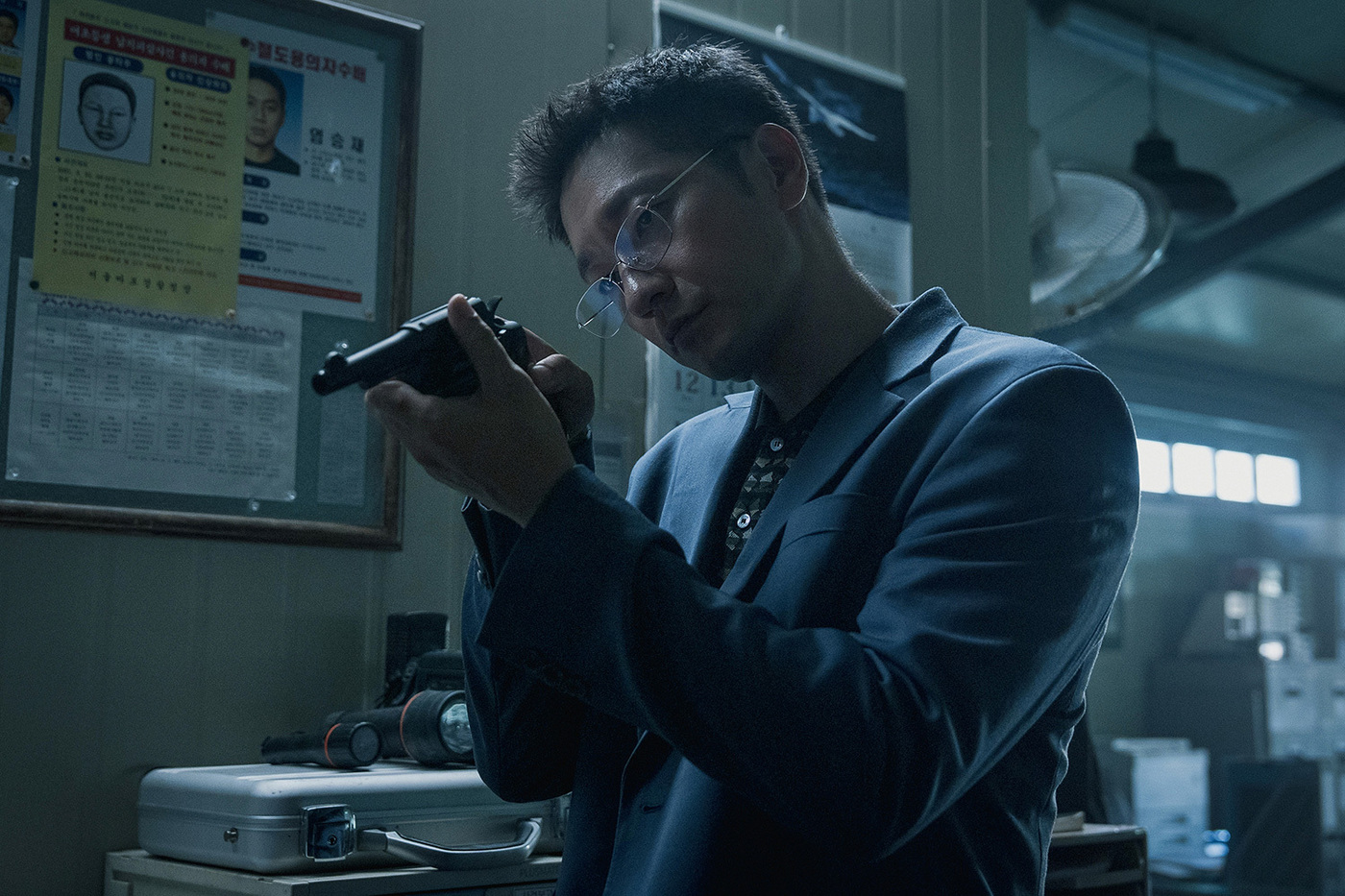 Netflixシリーズ『プルンギル』で、銃を手に事件現場を見つめるソン・ソック演じる刑事キム・ソク