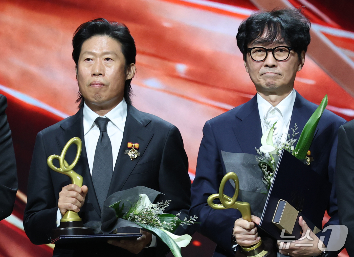 大統領表彰を手に並んで立つユ・ヘジン(左)とチャン・ハンジュン監督(右)