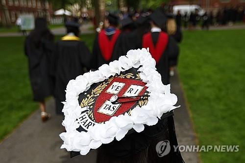 학사모에 '하얀 꽃'…<b>하버드</b> 졸업생, '외국 학생 차단'에 저항