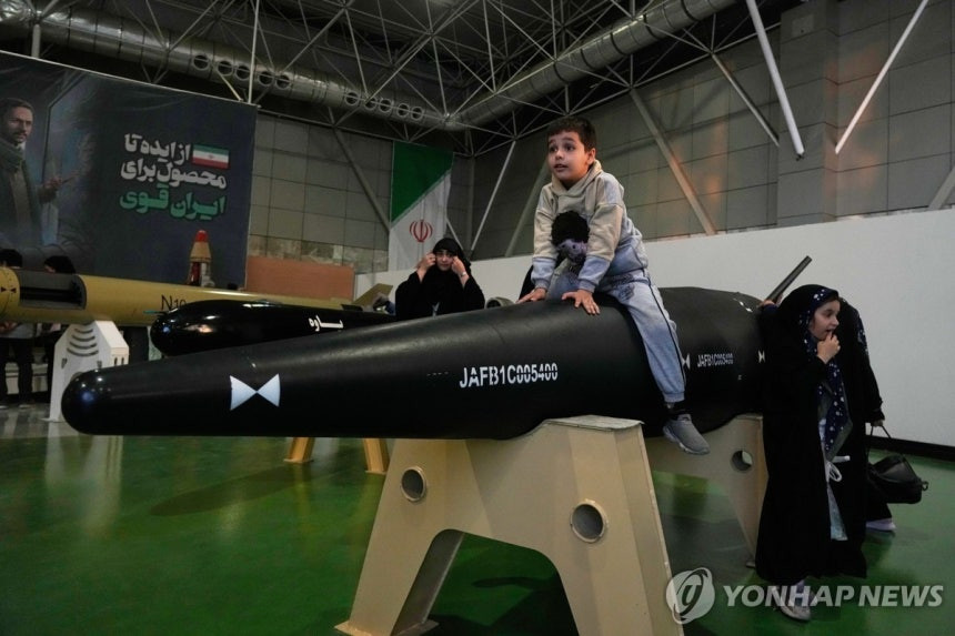 지난달 13일 이란 수도 테헤란 외곽 국립 우주항공 공원에서 한 소년이 전시된 미사일 위에 올라 앉아 있다.[AP=연합뉴스 제공]