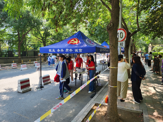 8日，高中官員歡迎在北京大學高中安裝的帳篷裡的考生，那裡舉行了中國大學入學考試Kaokao。通訊員李do -Sung。